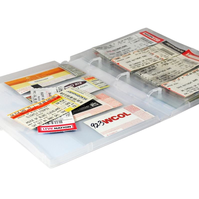 May include: A clear plastic ticket holder with multiple ticket stubs inside. The tickets are for various events, including concerts and sporting events. The holder has a clear plastic cover and a metal ring binder.