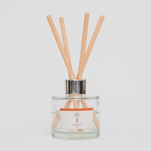 May include: A clear glass aromatherapy diffuser with a silver collar and light peach-coloured reeds. The diffuser has a white label with orange accents and text that reads "Yorkshire Spice". The product is designed for home fragrance.