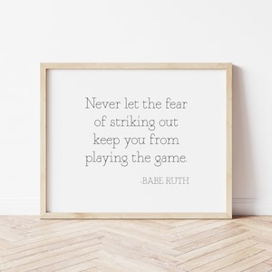 May include: A framed print with a motivational quote by Babe Ruth: "Never let the fear of striking out keep you from playing the game."