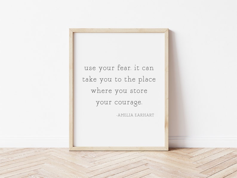 May include: A framed print with a quote by Amelia Earhart: "use your fear. it can take you to the place where you store your courage."