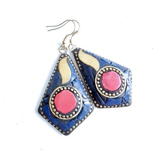 May include: A pair of blue and gold earrings with red stone accents. The earrings are made of metal and have a geometric shape.