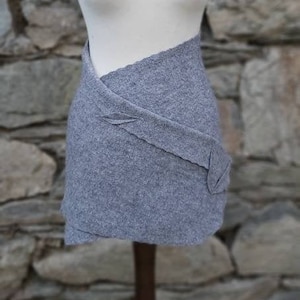 Peut inclure: Une jupe grise avec un design asymétrique unique. La jupe est faite d'un tissu doux et texturé et a un aspect fluide et drapé.