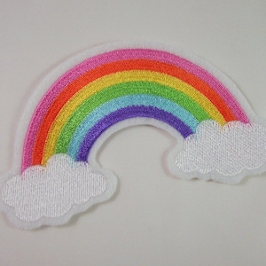 Könnte beinhalten: Ein gestickter Patch mit einem Regenbogen in sieben Farben: Rosa, Orange, Gelb, Grün, Hellblau, Lila und Rot. Der Regenbogen hat auf beiden Seiten weiße Wolken.