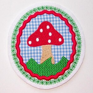 Könnte beinhalten: Ein roter und weißer Pilz mit weißen Punkten auf einem blau-weiß karierten Hintergrund. Der Pilz ist von grünem Gras und einem roten und weißen gewellten Rand umgeben.