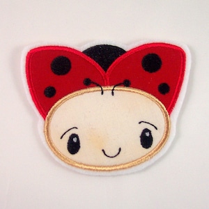 Könnte beinhalten: Ein roter und schwarzer Marienkäfer mit einem weißen Gesicht und schwarzen Augen. Der Marienkäfer lächelt und hat einen goldenen Umriss.