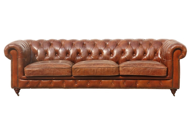 May include: A brown leather Chesterfield sofa with tufted buttons and rolled arms. The sofa has a classic design and is perfect for a traditional living room.