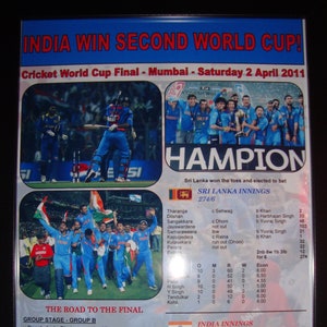 Op de afbeelding: Een krantenknipsel dat de overwinning van India in de finale van de Cricket World Cup 2011 viert. De kop luidt "India Win Second World Cup!" en bevat de datum "Saturday 2 April 2011". Het knipsel toont een foto van het Indiase cricketteam dat zijn overwinning viert, samen met een scorebord dat de eindscores voor zowel India als Sri Lanka laat zien.