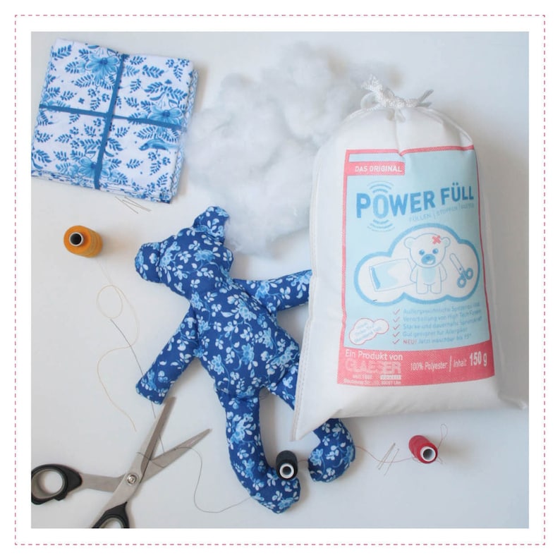 May include: A blue and white floral fabric teddy bear with stuffing and a bag of "Power F&uuml;ll" polyester fiberfill. The bag is white with blue text and a cartoon bear.