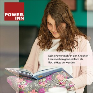May include: A young person is reading a book while sitting on a couch. The book is resting on a gray and white floral patterned cushion. The text on the image reads "Keine Power mehr in den Knochen? Leseknochen ganz einfach als Buchst&uuml;tze verwenden."