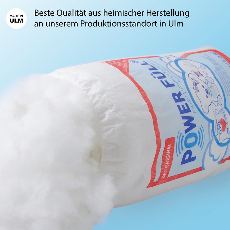May include: A white bag of filling material with a red and blue label that says "POWER F&Uuml;LL" and "DAS ORIGINAL". The label also has a cartoon bear with a red heart on its chest. The bag is partially open and the filling material is spilling out.