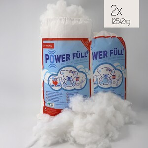 Könnte beinhalten: Zwei Beutel mit weißer Polyester-Füllwatte, jeweils 1250 Gramm, mit der Aufschrift "Power Füll" und "Wer Füll". Die Beutel befinden sich auf weißem Hintergrund. Die Füllwatte wird zum Füllen von Spielzeug, Kissen und anderen Bastelarbeiten verwendet.