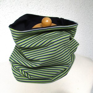 Könnte beinhalten: Ein grüner, grauer und schwarzer gestreifter Halsschmuck. Der Halsschmuck ist aus einem weichen, dehnbaren Stoff gefertigt und perfekt, um sich im Winter warm zu halten.