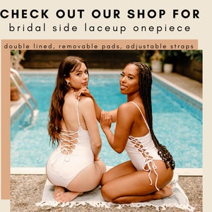 Op de afbeelding: Twee vrouwen in witte, met veters gekruiste badpakken poseren bij een zwembad. De tekst "CHECK OUT OUR SHOP FOR bridal side laceup onepiece double lined, removable pads, adjustable straps" staat boven de afbeelding.
