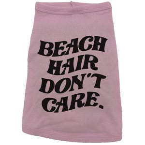 May include: Pink dog shirt with black text that reads "Beach Hair Don't Care."