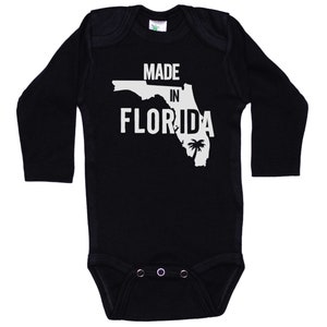 K&ouml;nnte beinhalten: Schwarzer Langarm-Babybody mit wei&szlig;em Text "Made in Florida" und einer Umrandung des Bundesstaates Florida mit einer Palme.
