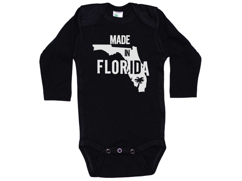 K&ouml;nnte beinhalten: Schwarzer Langarm-Babybody mit wei&szlig;em Text "Made in Florida" und einer Umrandung des Bundesstaates Florida mit einer Palme.