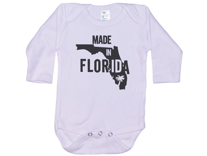 K&ouml;nnte beinhalten: Wei&szlig;er Langarm-Babybody mit schwarzem Text "Made in Florida" und einer schwarzen Umrandung des Bundesstaates Florida mit einer Palme.