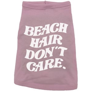 May include: A pink dog shirt with white text that reads "Beach Hair Don't Care."