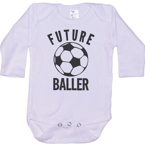 May include: White long-sleeve baby onesie with black text that reads "FUTURE BALLER" and a black and white soccer ball graphic.