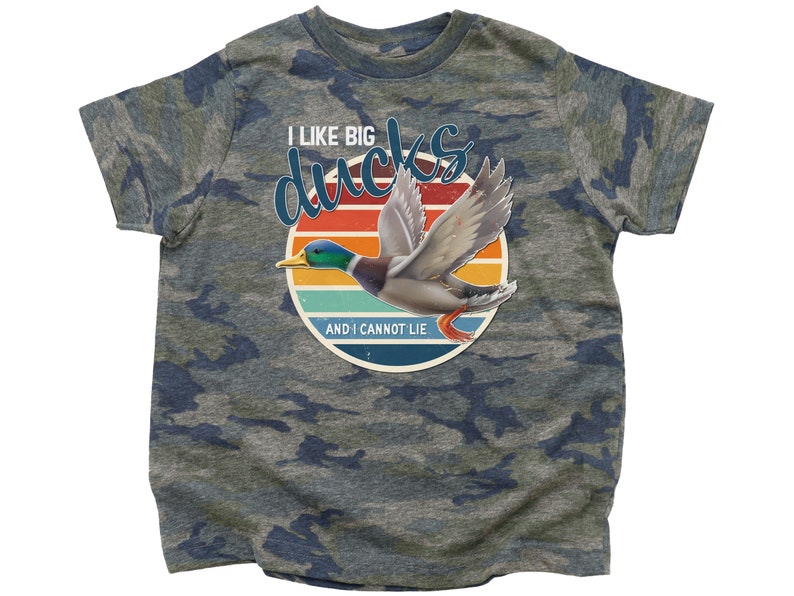 May include: A camouflage t-shirt with a retro-style graphic of a duck flying in front of a sunset. The text on the shirt reads "I like big ducks and I cannot lie."