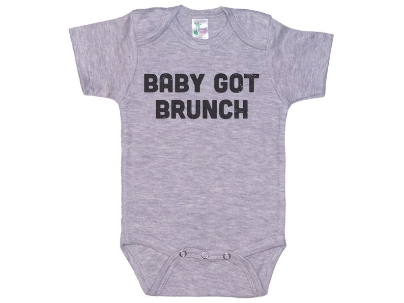 May include: A gray baby onesie with the text "BABY GOT BRUNCH" printed in black.