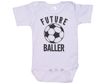 May include: White baby onesie with black text that reads "FUTURE BALLER" and a black and white soccer ball graphic.