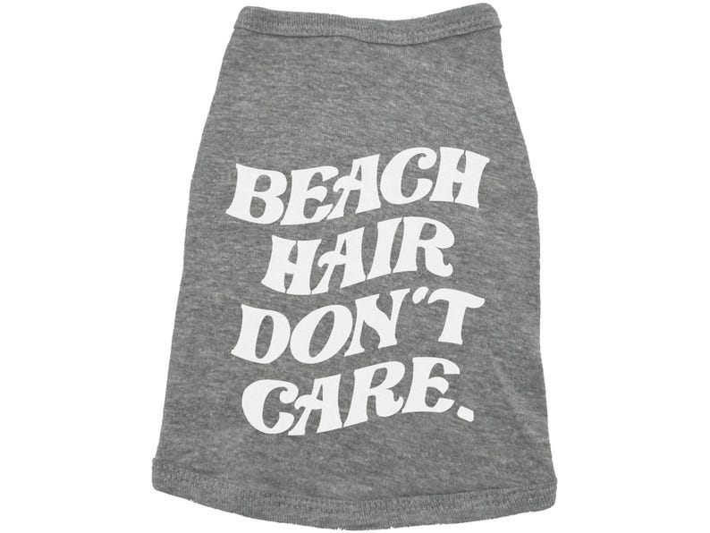 May include: Grey dog t-shirt with white text that reads "Beach Hair Don't Care."