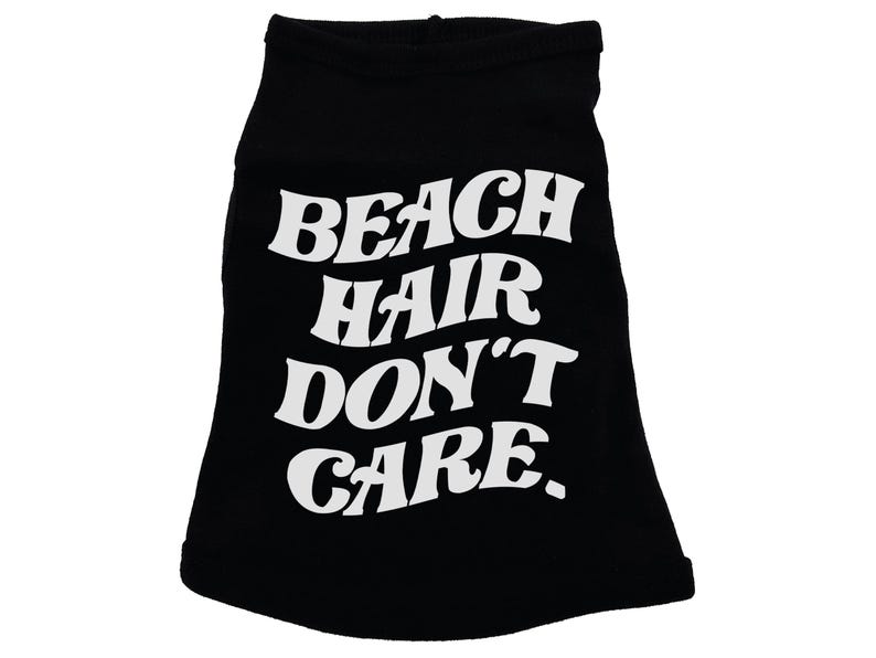 May include: Black dog shirt with white text that reads "Beach Hair Don't Care."