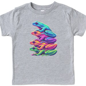 May include: A gray t-shirt with a graphic of four stacked frogs in rainbow colors. The frogs are green, blue, pink, and orange.