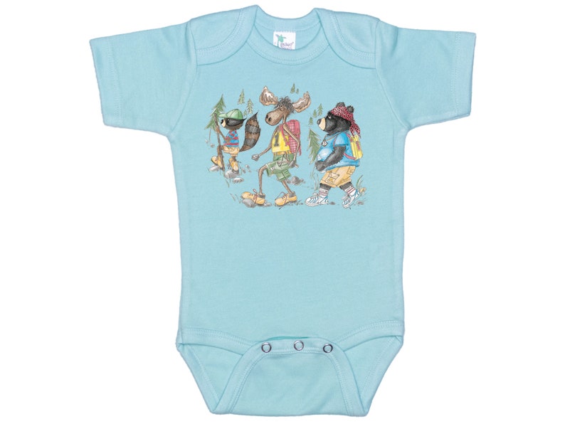 May include: A light blue baby onesie with a graphic print of a raccoon, moose, and bear wearing backpacks and hiking in the woods.