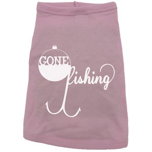May include: Pink dog shirt with a white graphic of a fishing bobber with the word "GONE" inside and the word "fishing" written in a cursive font below the bobber.