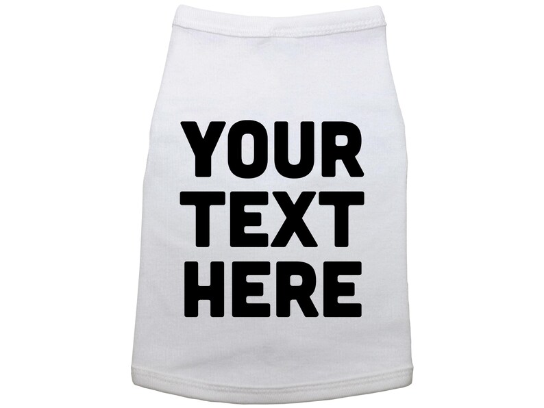 Op de afbeelding: Witte hondenshirt met zwarte tekst die "YOUR TEXT HERE" zegt.
