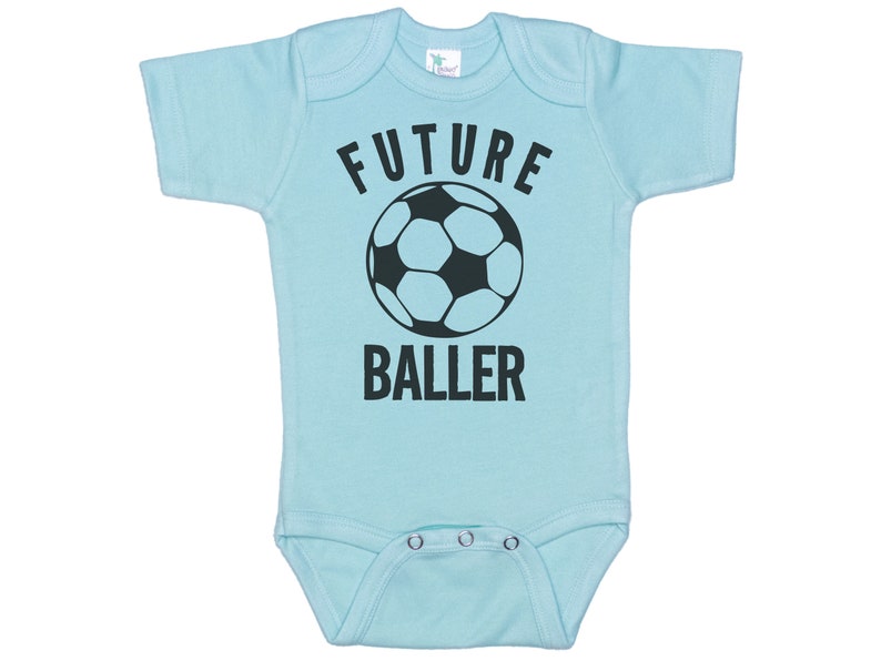 May include: A light blue baby onesie with a black soccer ball and the text "FUTURE BALLER" printed on the front.
