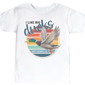May include: White t-shirt with a retro sunset graphic and a flying duck. The text reads "I like big ducks and I cannot lie."
