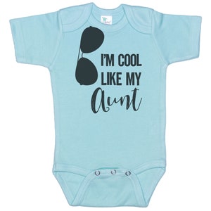 May include: A light blue baby onesie with a black graphic of sunglasses and the text "I'm cool like my aunt".