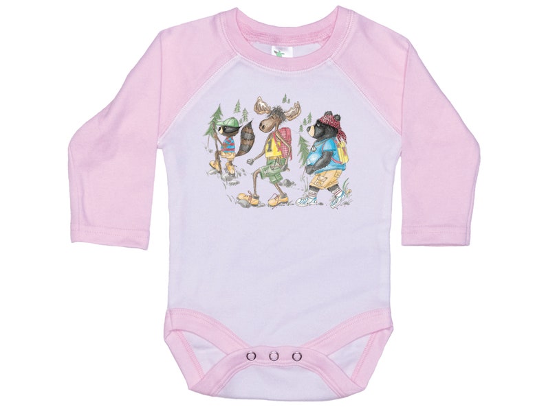 May include: Pink long-sleeve baby onesie with a white front featuring a cartoon illustration of a moose, a bear, and a raccoon wearing backpacks and hiking in the woods.