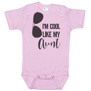 May include: Pink baby onesie with a black graphic of sunglasses and the text "I'm cool like my aunt".