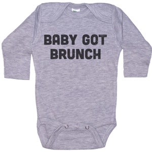 May include: A gray long-sleeve baby onesie with black text that reads "BABY GOT BRUNCH".