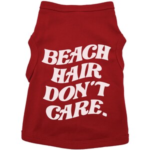 May include: Red sleeveless dog shirt with white text that reads "Beach Hair Don't Care."