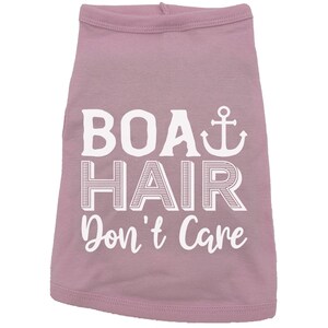 Puede incluir: Una camiseta rosa para perro con texto blanco que dice "Boat Hair Don't Care" y un s&iacute;mbolo de ancla blanco.