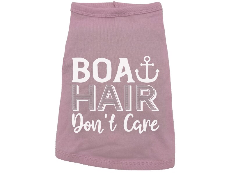 Puede incluir: Una camiseta rosa para perro con texto blanco que dice "Boat Hair Don't Care" y un s&iacute;mbolo de ancla blanco.
