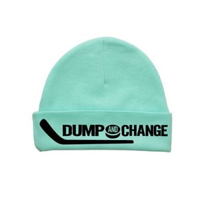 May include: A light blue beanie with a black hockey stick and the text "DUMP AND CHANGE" on the front.