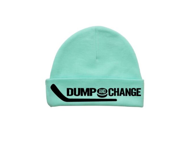 May include: A light blue beanie with a black hockey stick and the text "DUMP AND CHANGE" on the front.