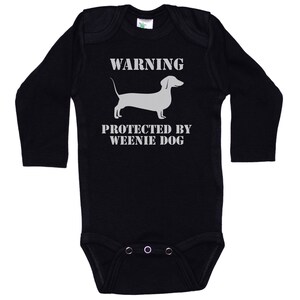 May include: Black long-sleeve baby onesie with a white dachshund silhouette and the text "WARNING PROTECTED BY WEENIE DOG".