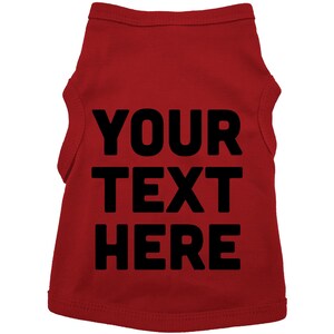 Op de afbeelding: Rood, mouwloos honden T-shirt met zwarte tekst die "YOUR TEXT HERE" zegt.