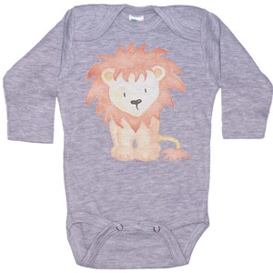 May include: A gray long-sleeved baby onesie with a watercolor illustration of a brown and orange lion with a red mane.