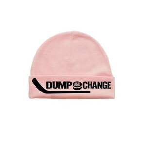 May include: Pink knit beanie with a black hockey stick and puck graphic and the text "DUMP AND CHANGE".
