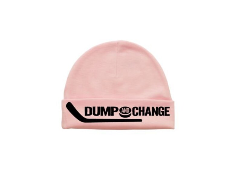 May include: Pink knit beanie with a black hockey stick and puck graphic and the text "DUMP AND CHANGE".