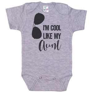 May include: Gray baby onesie with a black graphic of sunglasses and the text "I'm cool like my aunt".