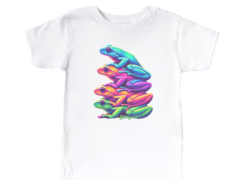 May include: A white t-shirt with a graphic of four frogs stacked on top of each other. The frogs are different colors: green, blue, pink, and yellow.